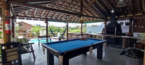 a pool table in the middle of a room with a kitchen at Pousada Além do Mar in Praia do Rosa