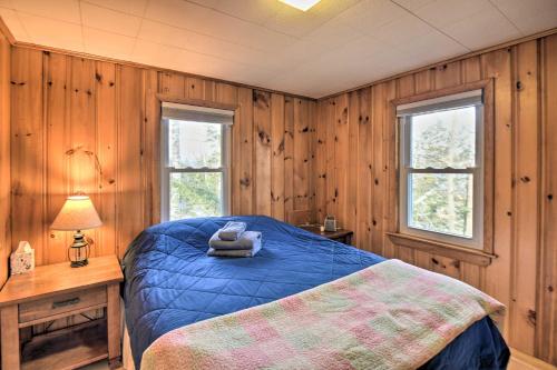 a bedroom with a blue bed and two windows at Updated Bristol Lakehouse with Kayaks and Beach Access in Bristol