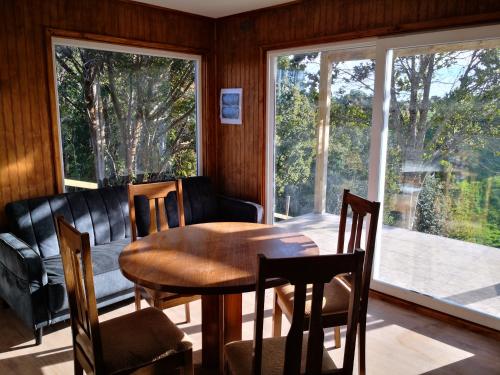 a dining room with a table and chairs and a window at Cabañas Mirador Los Avellanos in Castro
