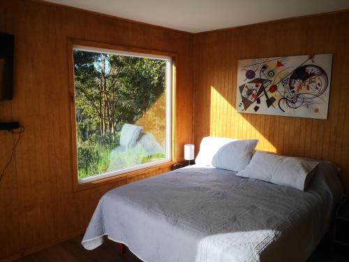 una camera con letto e finestra di Cabañas Mirador Los Avellanos a Castro