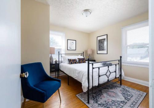 um quarto com uma cama e uma cadeira azul em Spacious 2BR Home In Kentucky em Louisville