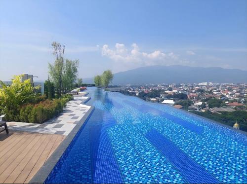 a large swimming pool with a view of a city at Astra Sky River Condo in Chiang Mai