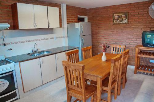 a kitchen with a wooden table and a refrigerator at Altos del Plata in Villa Carlos Paz