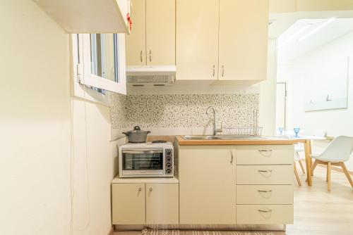 a kitchen with white cabinets and a microwave at Boutique Apartment with ParkView in Heraklio Town