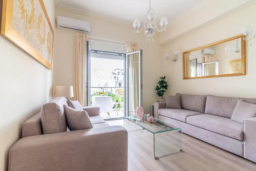 a living room with two couches and a glass table at Boutique Apartment with ParkView in Heraklio Town