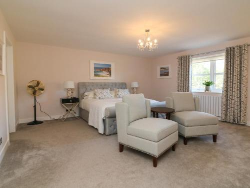 a bedroom with a bed and a table and chairs at 4 Woodland Park in Bideford