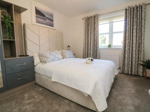 a bedroom with a bed with a teddy bear on it at 4 Woodland Park in Bideford