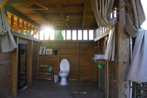 a bathroom with a toilet in a wooden cabin at Samana Ecolodge in El Limón