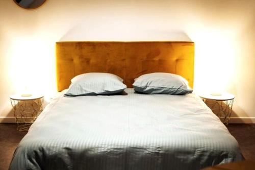 a bedroom with a large bed with two pillows at Le Nid • Cocoon • Netflix • Proche Centre-Ville in Châteauroux