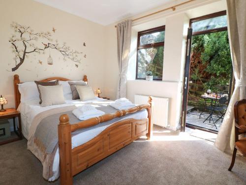 a bedroom with a bed and a large window at Amber Cottage in Matlock