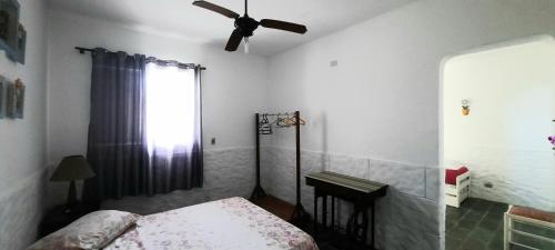 a bedroom with a bed and a ceiling fan at PousadaRecanto684Guarujá in Guarujá