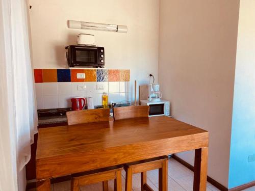 a kitchen with a wooden table with chairs and a microwave at Terrazas de Lobos in Lobos