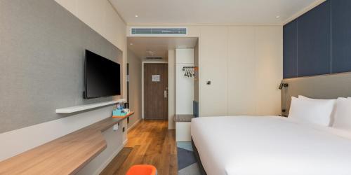 a hotel room with a bed and a flat screen tv at Holiday Inn Express Taiyuan High Tech Zone by IHG in Taiyuan