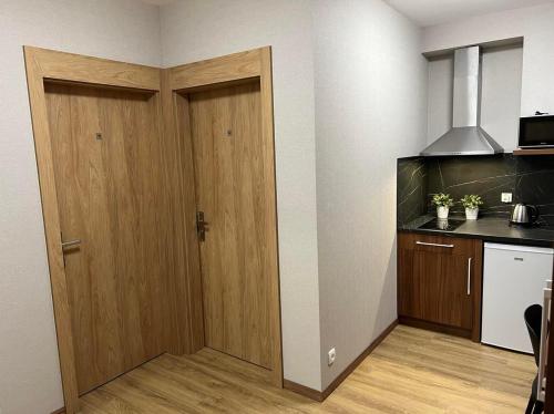 a kitchen with two wooden doors in a room at Apartamenty Polna 60 in Żory