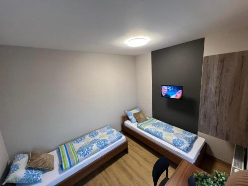 Zimmer mit 2 Betten und einem TV an der Wand in der Unterkunft Apartamenty Polna 60 in Żory