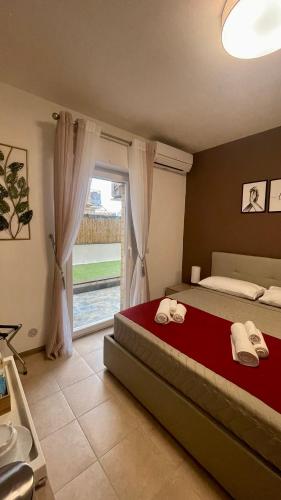 a bedroom with a bed and a large window at AMERICAN GARDEN HOUSE in Nettuno