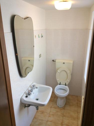 uma casa de banho com um lavatório, um WC e um espelho. em La casa di UGO em Ciglione
