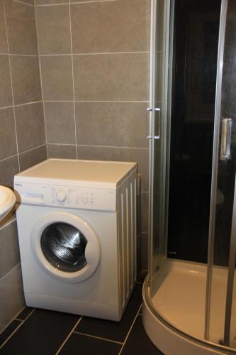 een wasmachine in een badkamer met een douche bij 3 Zimmer Apartment am Leopoldplatz in Berlijn