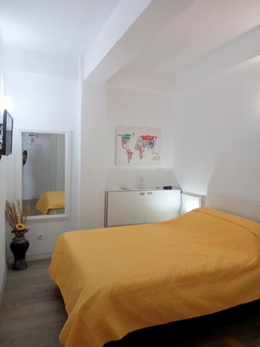 a bedroom with a yellow bed and a mirror at Machico Centre Comfort in Machico