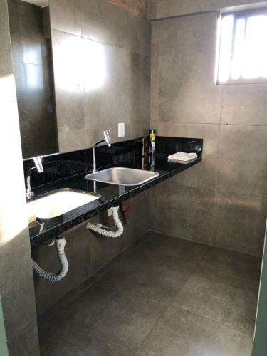 a bathroom with two sinks and a large mirror at Ilusion hotel ponta negra Natal in Natal