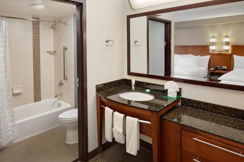 a bathroom with a sink and a toilet and a mirror at Hyatt Place Princeton in Princeton