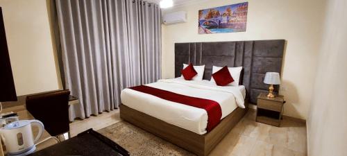 a bedroom with a large bed with red pillows at Golden Hotel in Amman