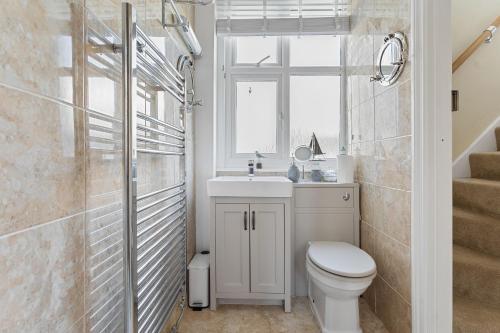 een badkamer met een toilet, een wastafel en een raam bij Captains Cottage - Stylish cottage, level location, in the heart of Dartmouth in Dartmouth