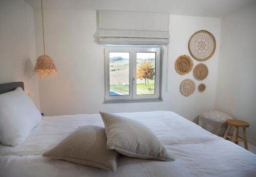 een wit bed met een raam in een slaapkamer bij Vakantiewoningen Liefst in Epen in Epen