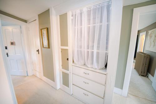 Cette chambre comprend une commode blanche et une fenêtre. dans l'établissement Spacious three bedroom home with a large deck!, à Columbus