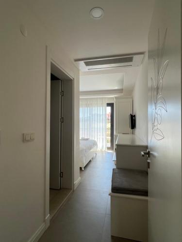 biały pokój z łóżkiem i drzwiami do sypialni w obiekcie Dalyan Risus Suite w mieście Çeşme