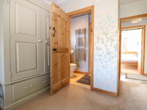 a bathroom with a door leading to a bedroom at 1 Northside Cottages in Godalming