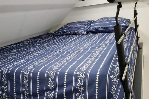 uma cama com lençóis e almofadas azuis e brancos em *Le Cristal Doré*Wifi*Parking em Lens