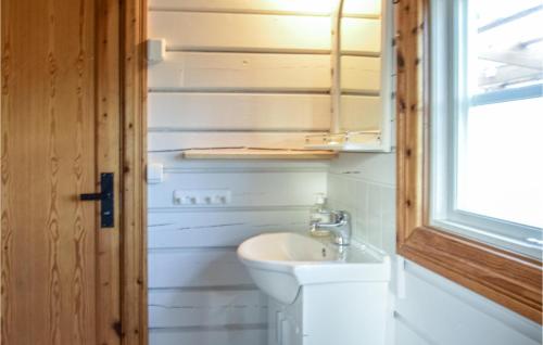 a bathroom with a sink and a toilet and a window at 1 Bedroom Gorgeous Home In Farsta 