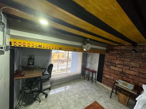 a room with a desk and a brick wall at Habitación con baño privado en aparthotel in Manizales