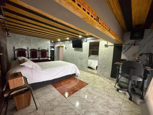 a bedroom with a bed and a desk and a chair at Habitación con baño privado en aparthotel in Manizales