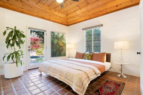 a bedroom with a large bed and two windows at Hacienda Salida in Palm Springs