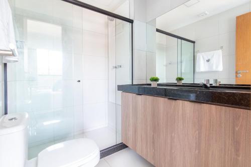 uma casa de banho com um lavatório, um WC e um espelho. em Mana Beach #B016 - Quadrúplo por Carpediem em Porto de Galinhas