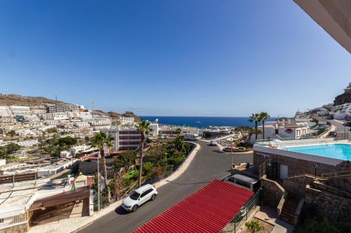 a white car parked on a street next to a city at Peace and View Apartment Puerto Rico in Puerto Rico de Gran Canaria