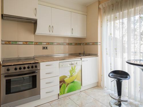 Una cocina con gabinetes blancos y una estufa. en Apartamento el Pilar 4, en Zaragoza