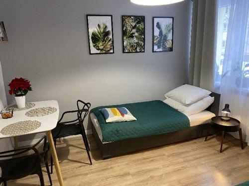 sypialnia z łóżkiem, stołem i krzesłami w obiekcie Apartamenty Błogi Sen II- komfortowy nocleg w spokojnej lokalizacji w Zabrzu