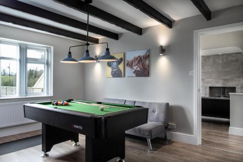 a living room with a pool table and a chair at Pen-y-Coed ⥈ Modern ⥈ Hot Tub ⥈ Beautiful Views in Abergele