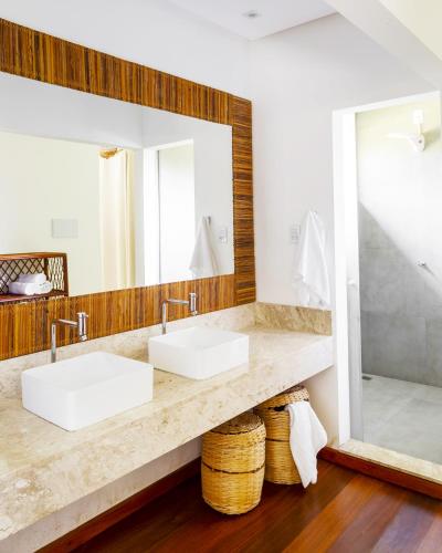 a bathroom with two sinks and a large mirror at Paraiso do Dende - Barra Grande - Beira Mar in Barra Grande