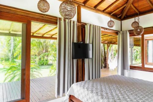 een slaapkamer met een bed en een groot raam bij Paraiso do Dende - Barra Grande - Beira Mar in Barra Grande