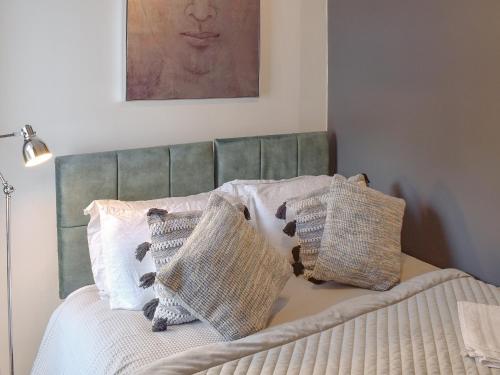 a bedroom with a bed with pillows and a painting at Deleur House in Great Malvern