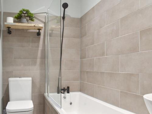 a bathroom with a tub and a toilet and a sink at Deleur House in Great Malvern