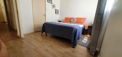 a bedroom with a bed with an orange pillow on it at Departamento cercano al faro y playa in La Serena