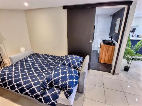 una camera da letto con un piumone bianco e blu su un letto di Le Petit Rocher 30m2- Studio standing tout confort a Saint-Aignan-Grand-Lieu