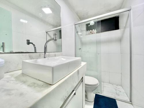 Baño blanco con lavabo y aseo en cruzeiro novo QD 203, en Brasilia