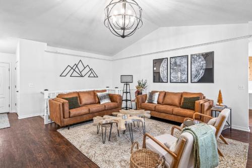 a living room with two couches and a table at Quiet Comfortable Cliffside Estate near USU in Logan