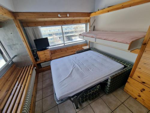 Cette petite chambre comprend 2 lits superposés et une télévision. dans l'établissement Panoramic Apartment Marilleva 1400, à Mezzana